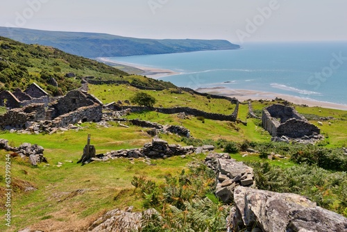 view of a ruined village in the mountains and the sea and green fields in Barmouth, UK