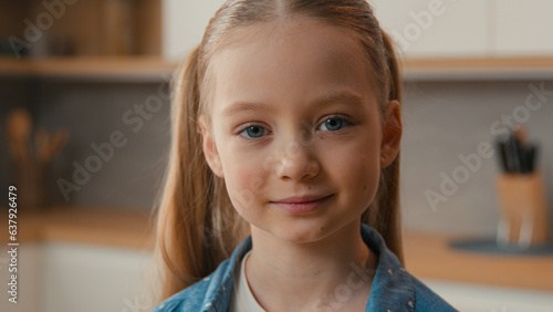 Cuadro en lienzo Moving shot close up little schoolgirl Caucasian child girl smiling looking at c
