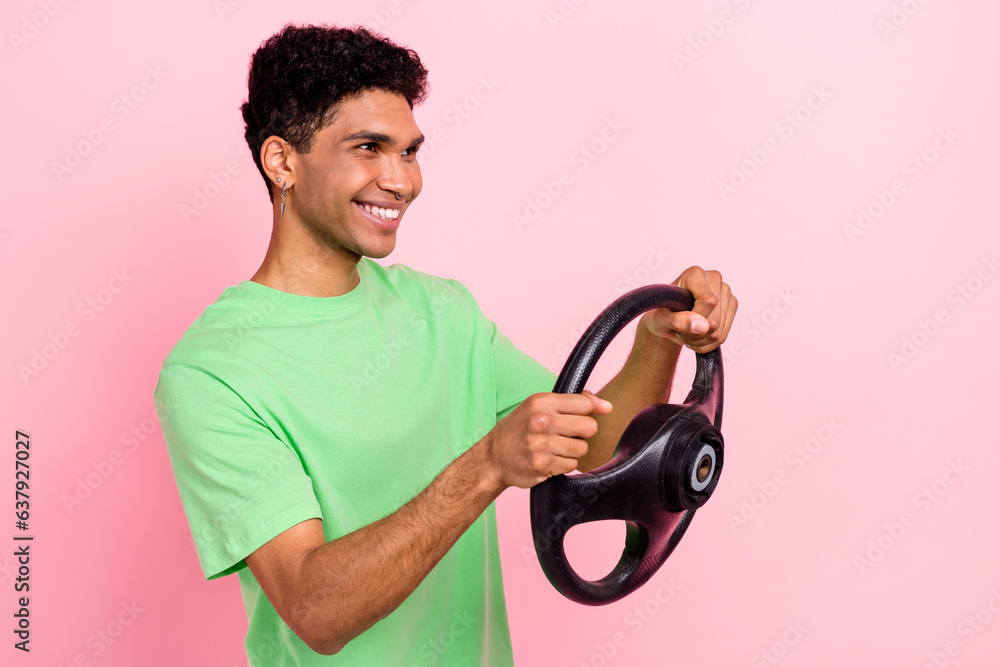 Photo of positive nice man wear stylish green clothes drive car look road empty space isolated on pink color background Photo of positive nice man wear stylish green clothes drive car look road empty space isolated on pink color background