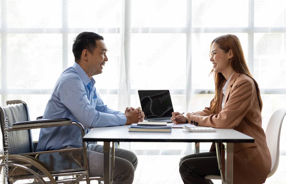 Man in wheelchair talking to female manager in office about recruitment and job interview. Man in wheelchair talking to female manager in office about recruitment and job interview.