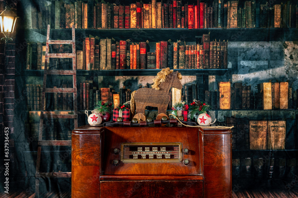 antique radio decorated for Christmas with hobby horse sleigh bells and presents with old library background