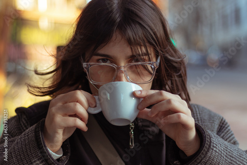 person/ woman drinking coffee in the city 