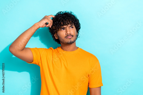 Photo of minded pensive person hand finger scratch head look empty space contemplate isolated on teal color background photo