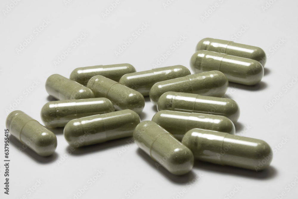 Herbs in several transparent capsules on a white background. Herbs in several transparent capsules on a white background.