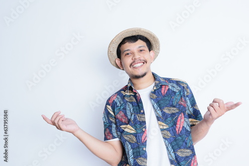 portrait of a young man wearing a beach suit smiling and giving open hands gesture at the camera. vacation and traveling concept photo