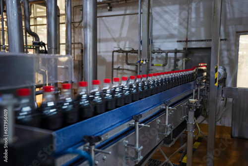 Beverage factory interior. Conveyor flowing with bottles contain for carbonated
