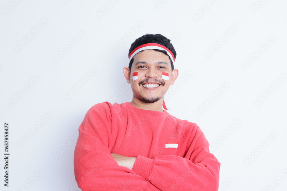 an indonesian man wearing a headband, crossing his arms while looking confidently at the camera. indonesian independence day concept an indonesian man wearing a headband, crossing his arms while looking confidently at the camera. indonesian independence day concept