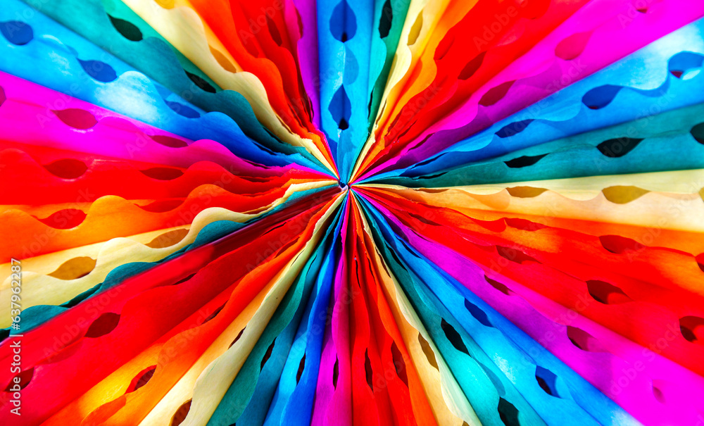 Rainbow colored paper decorations close-up abstract background top view 