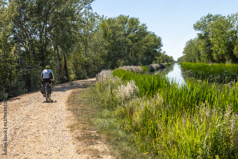 Obraz premium paseando en bicicleta con alforjas por el canal de Castilla 