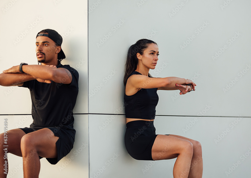 Fitness couple exercising together. Man and woman doing wall squat ...