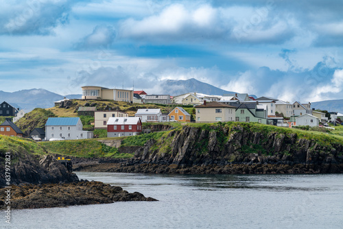 Stykkisholmur, Iceland, as seen from the water. Nordic homes and buildings perched on dramatic cliffs © MelissaMN