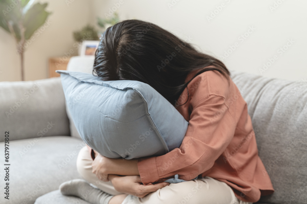 Stressed female feeling depressed and lonely on the sofa in the house. Stressed female feeling depressed and lonely on the sofa in the house.