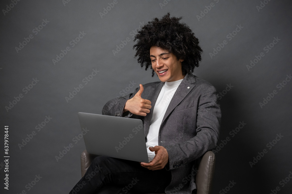 Curly-haired young manager working on laptop Curly-haired young manager working on laptop