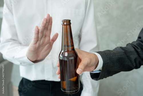 man refuses say no and avoid to drink alcohol at work, stopping hand sign male, alcoholism treatment, alcohol addiction, quit booze, Stop Drinking Alcohol. Refuse Glass liquor, unhealthy, reject photo