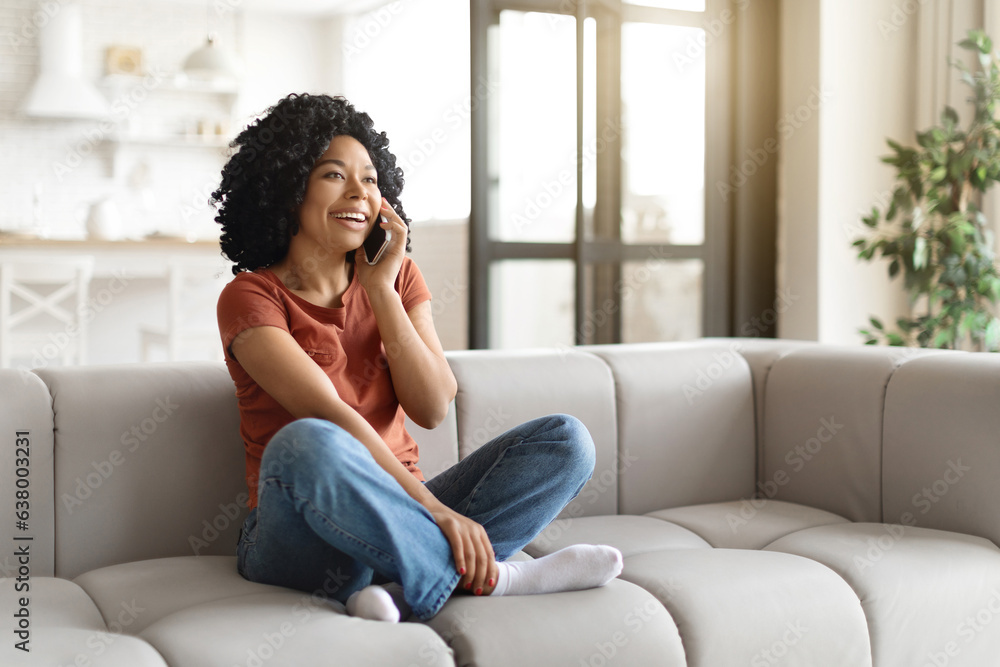 Young Black Woman Having Phone Call While Relaxing On Couch At Home Young Black Woman Having Phone Call While Relaxing On Couch At Home