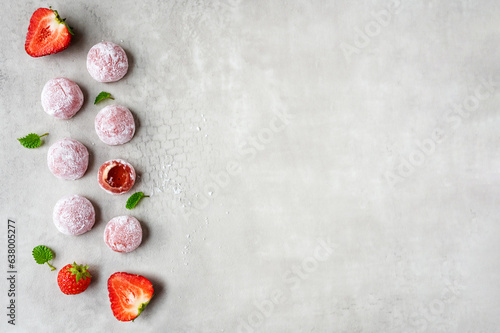 Rows of mochi with strawberries on a gray background.