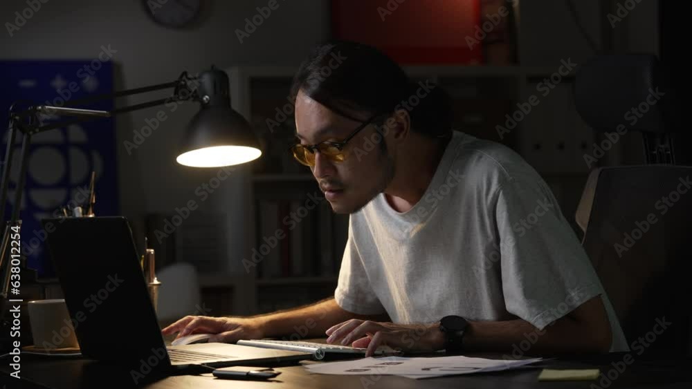 Asian man graphic designer working on computer drawing sketches logo design. Young Asian businessman looking serious and stressed while using laptop to work from home. Asian man graphic designer working on computer drawing sketches logo design. Young Asian businessman looking serious and stressed while using laptop to work from home.