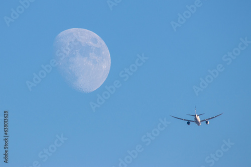 Un aereo nel cielo accanto alla luna