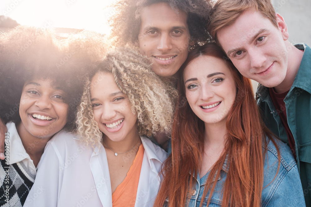 Portrait of a group of young people of different origins smiling at sunset together. Concept: lifestyle, friendship, teamwork