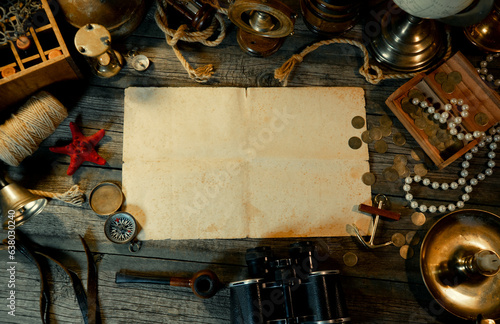 Sheet of paper on rustic wood table with vintage marine objects. Treasure island background. Hold of a ship.