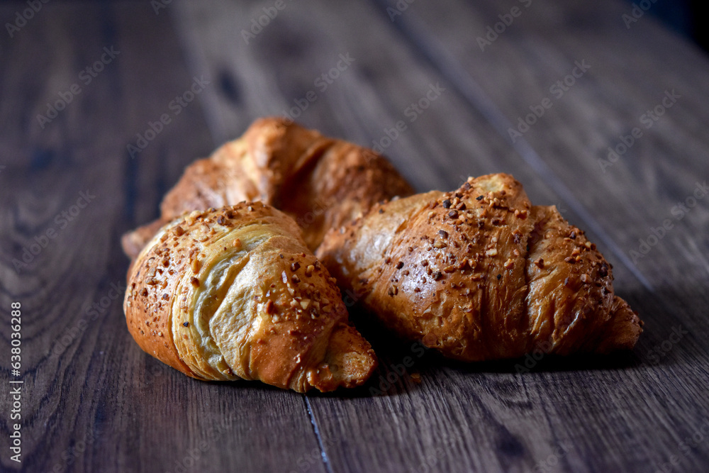 fresh baked croissants on rustic wooden table 