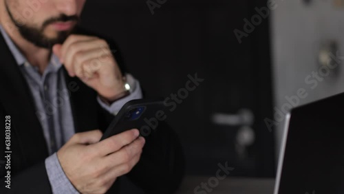 Businessman working in the office talking on the phone and having a laptop in front of him