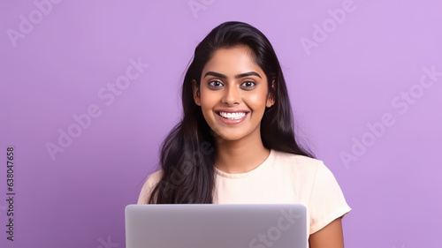 Happy Indian woman with laptop computer working or studying online on lilac background.generative ai © JKLoma