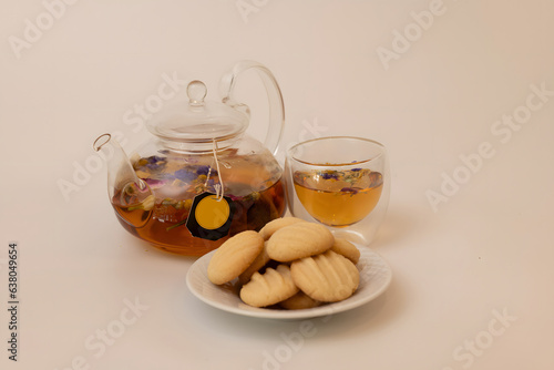 FlowersTea party set . tea pot with a cup of tea and butter cookies isolated background  photo