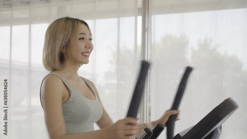 Woman running on running machine at home.Full length profile shot of a fit woman jogging on a treadmill. Woman running on running machine at home.Full length profile shot of a fit woman jogging on a treadmill.