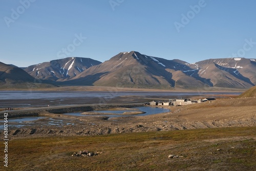 Mountain panorama with old wooden buildings by water, around city Longyearbyen. Former mining town Longyearbyen, capital of Svalbard, Spitsbergen, Norway. 