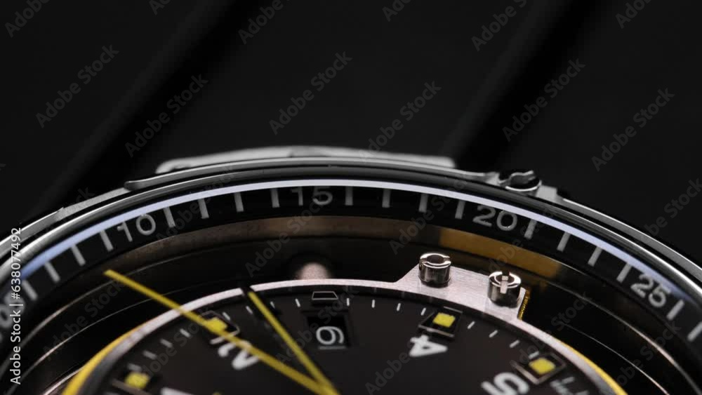Extreme closeup of yellow second arrow passing by on black clock face. Lengthwise view of luxury swiss watch. Closeup real time shot. Running second arrow. blank dial Extreme closeup of yellow second arrow passing by on black clock face. Lengthwise view of luxury swiss watch. Closeup real time shot. Running second arrow. blank dial