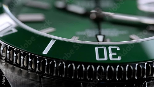 Stylish Luxury Man Wrist Watch With Moving Hand And Multiple Dials. Men's watch in metal with sapphire crystal. Closeup view of rotating watch, running second arrow. green dial. Cyclops watch