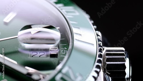 Stylish Luxury Man Wrist Watch With Moving Hand And Multiple Dials. Men's watch in metal with sapphire crystal. Closeup view of rotating watch, running second arrow. green dial. Cyclops watch