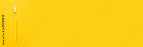 Plastic toothbrush on the yellow background with copy space