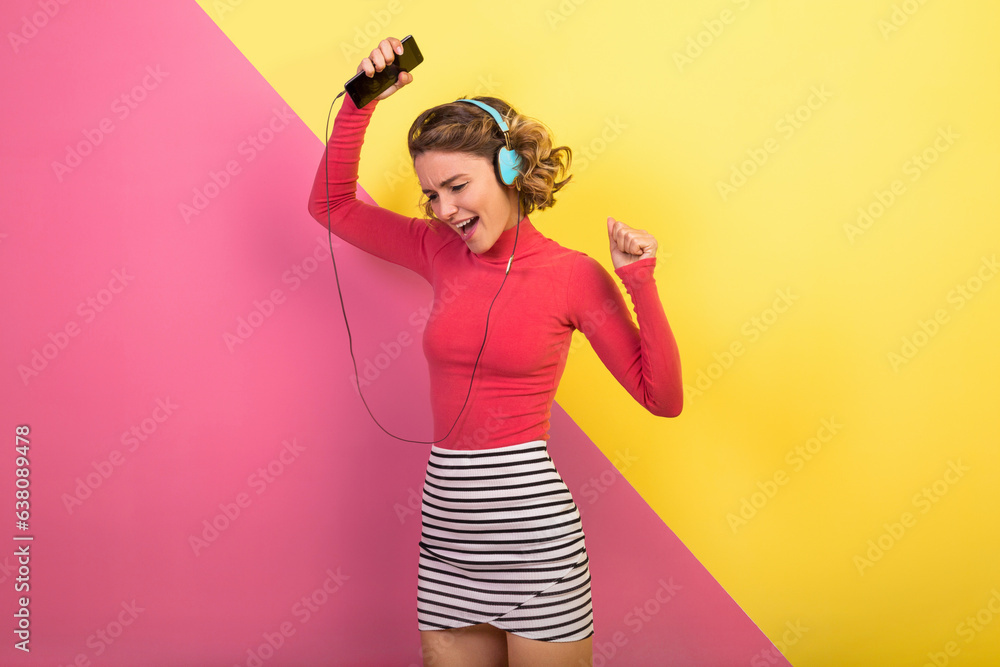 smiling attractive smiling excited woman in stylish colorful outfit dancing and listening to music smiling attractive smiling excited woman in stylish colorful outfit dancing and listening to music