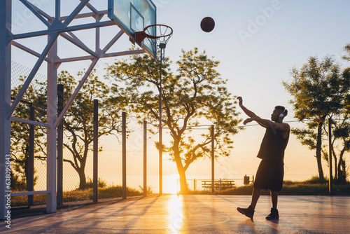 black man doing sports, playing basketball on sunrise, active lifestyle, sunny summer morning © mary_markevich