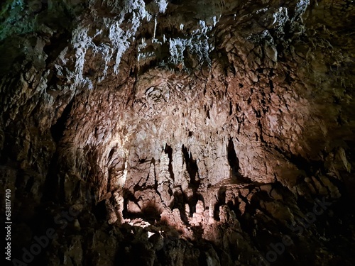 Fotografia grotta con stalattiti e stalagmiti, attraversata dal fiume