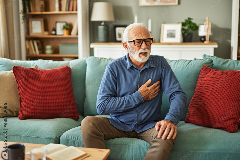 A senior man suffering from chest pain or heart attack at home