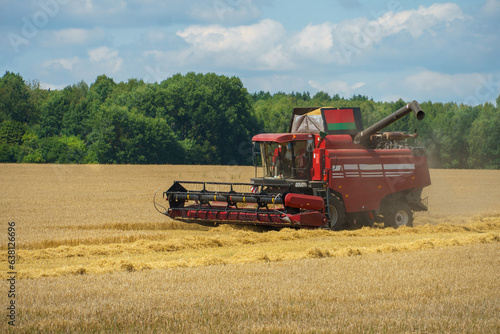 The combine harvester is working in the field. Agro-industrial complex  grain harvest season. Harvesting and harvesting of wheat  flour production. Grain deal.