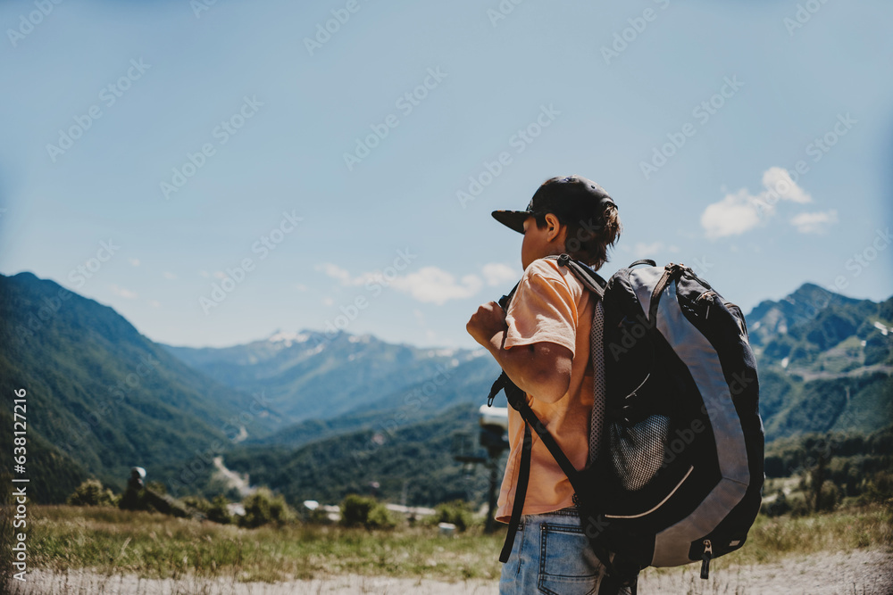 caucasian tourist boy with backpack in mountains
