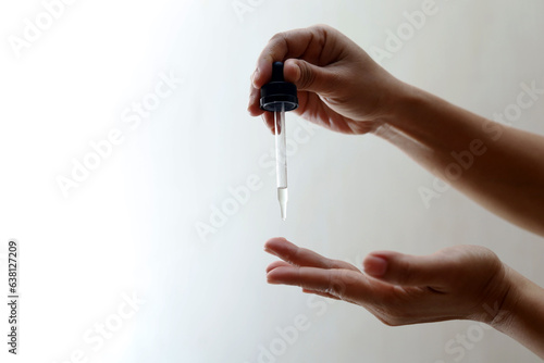 Women's hands hold pipette with cosmetic serum  photo