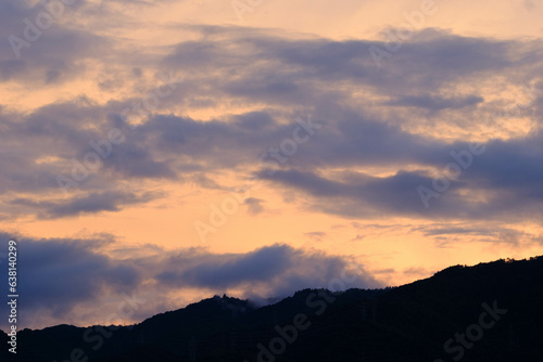 夜明け前、六甲の山並みと空。上空の雲が赤く染まり一日が始まる。早朝神戸市内から撮影