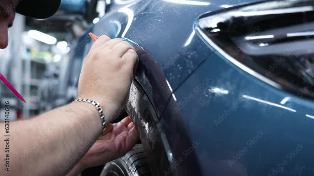 The master in the car service applies an armor film to the car. The master in the car service applies an armor film to the car.