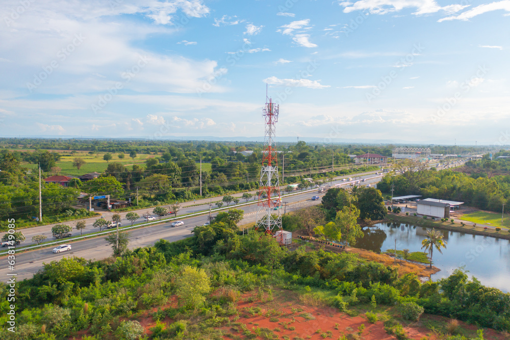 Obraz premium Aerial view of TV antenna in the middle of a city , red roofs on a housing community, vacant lots, urban and rural view.