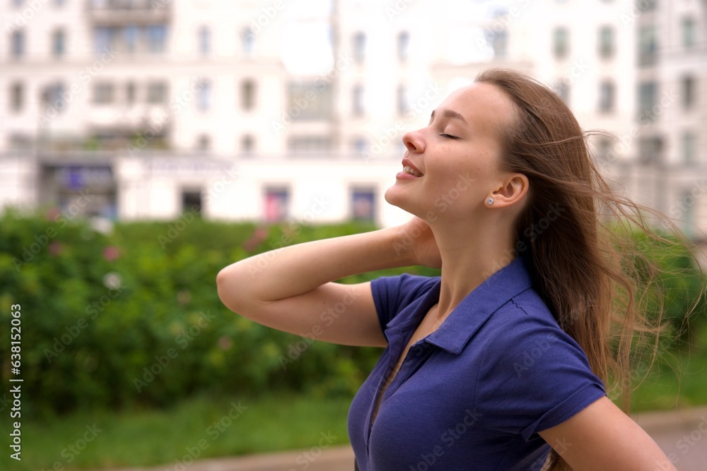 Young woman walk in a yard of her new city flat, apartment in residential complex at summer day