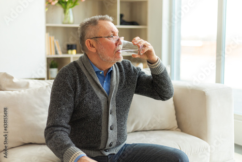 Bilde på lerret Senior man holding glass drinking fresh water at home