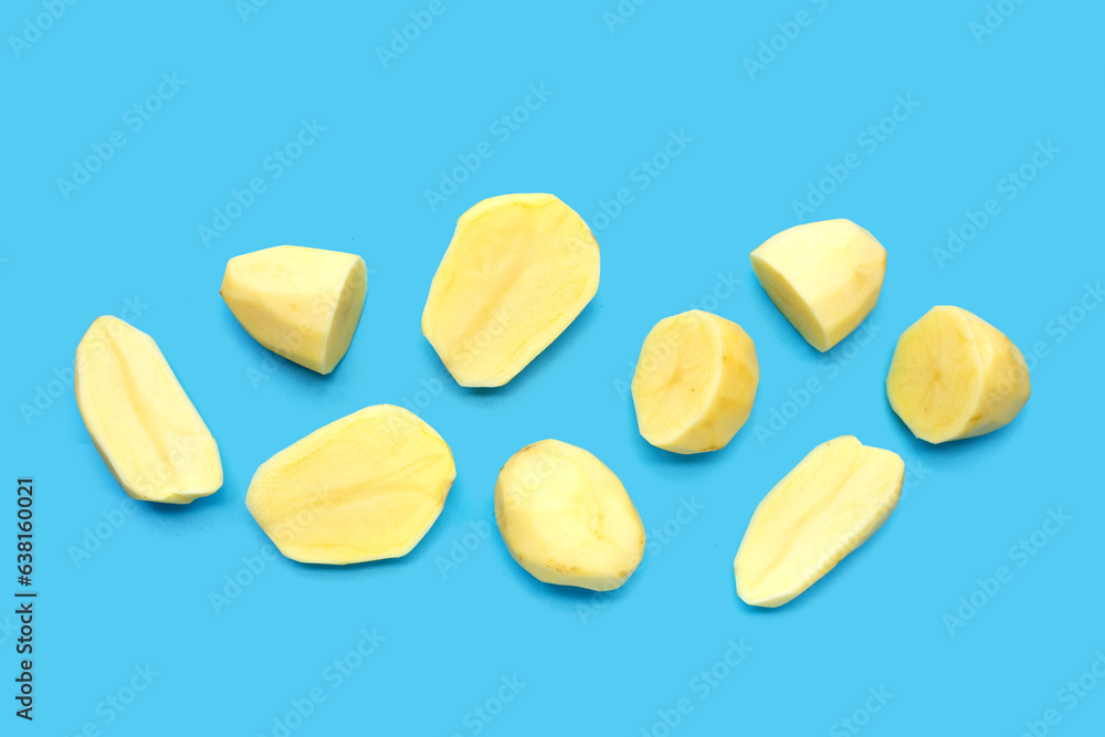Raw peeled potatoes on blue background Raw peeled potatoes on blue background