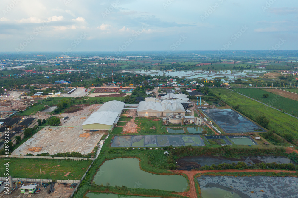 Aerial view of stack of different types of large garbage pile, plastic bags, and trash with a tractor car in industrial factory in environmental pollution. Waste disposal in dumping site.