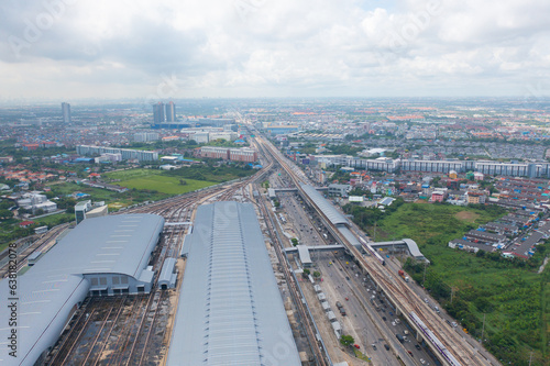 Aerial view of Bangkok Railway terminal station, BTS with skyscraper buildings in urban city, Bangkok downtown skyline, Thailand. Cars on traffic street road on highways. © tampatra