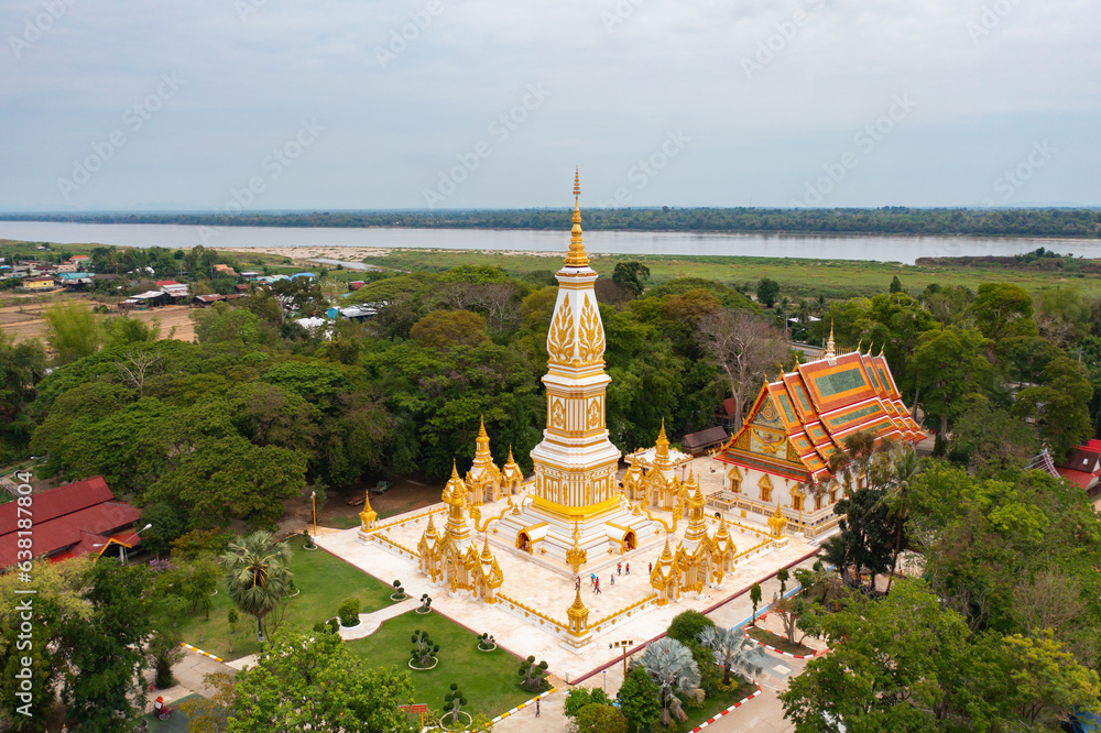 Naklejka premium Wat Phrathat Phanom, Nakhon Phanom, Isan Temple. The pagoda is a buddhist temple in urban city town, Thailand. Thai architecture landscape background. Tourist attraction landmark.